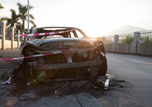 closeup of a burned out car on roadside